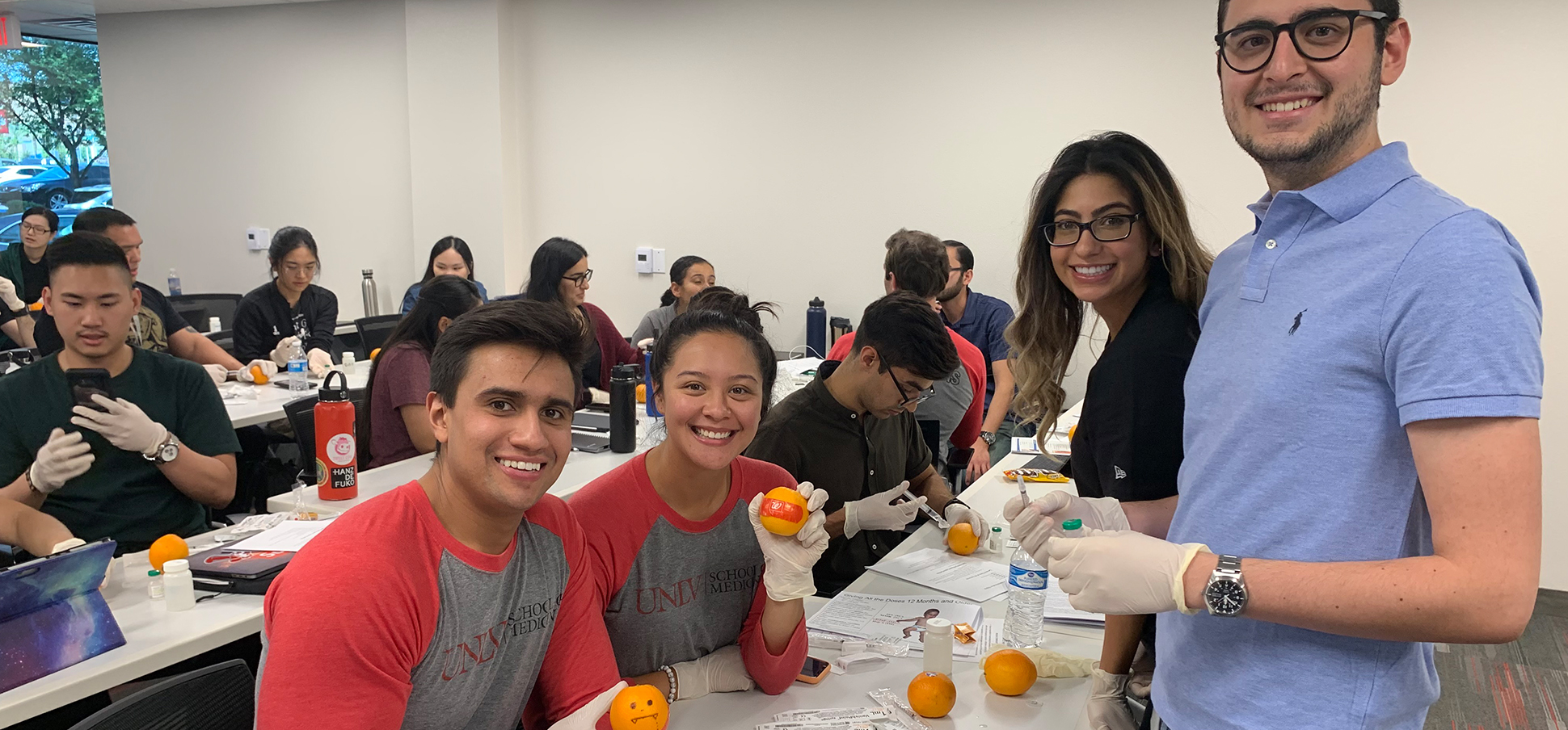 Medical students training on immunizations with oranges