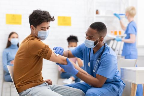 Young person getting a vaccine from a medical provider.